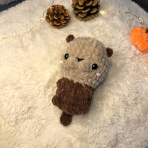 Gehäkelter Baby Otter in beige und braun.