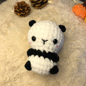 Gehäkelter Baby Panda in weiß und schwarz.